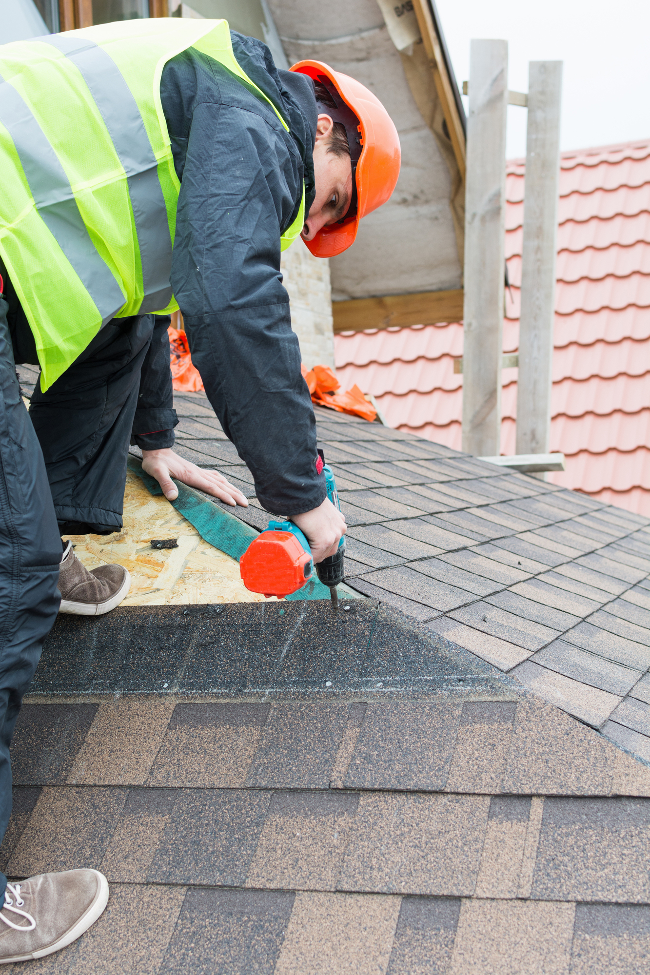 Kalamazoo Roofer builder worker dismantling roof shingles